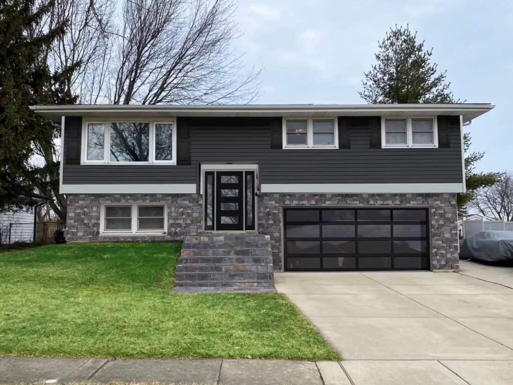 A renovated house featuring dark gray siding and stone veneer installed by A&D Exteriors in Naperville, IL.