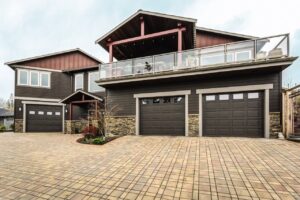 A large house featuring three dark brown garage doors installed by Overhead Door Company of Little Rock in North Little Rock, AR.