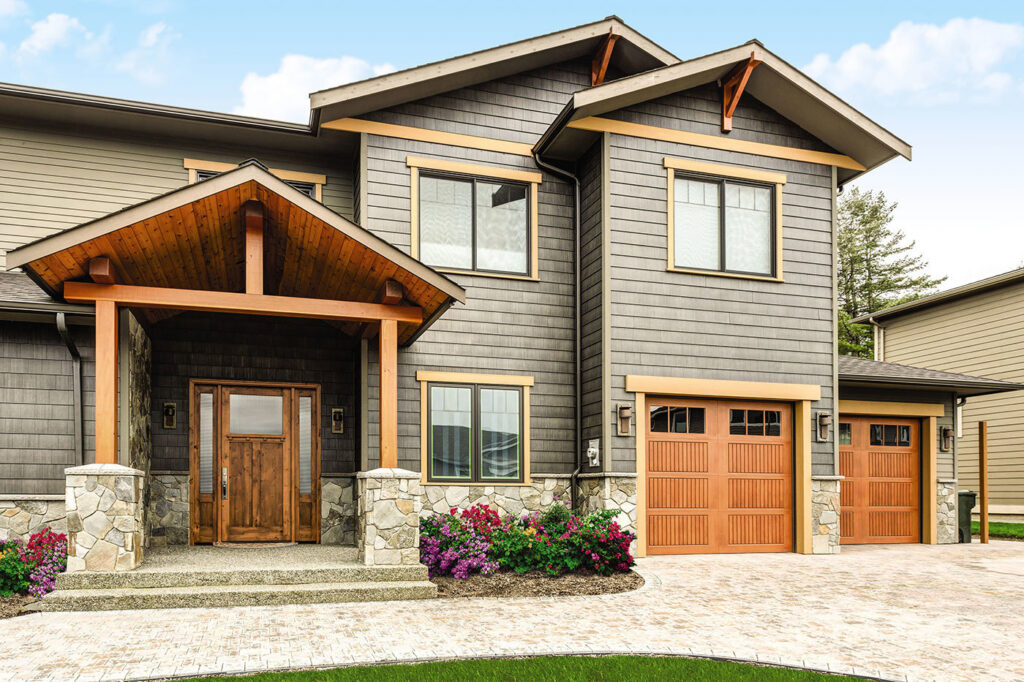 A residential property showcasing two wooden-style garage doors installed by Overhead Door Company of Little Rock in North Little Rock, AR.