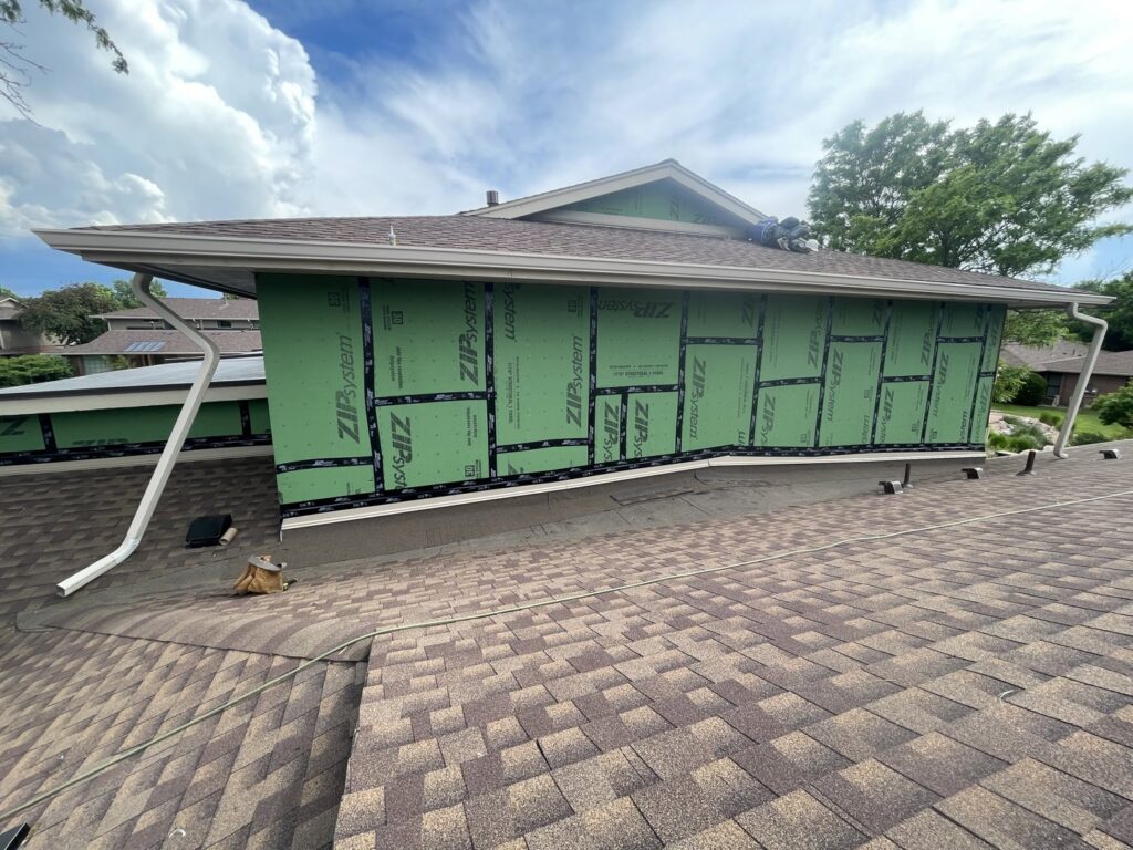 House wrapped in green ZIP System sheathing, indicating siding preparation by EZ General Construction in Colorado Springs, CO.