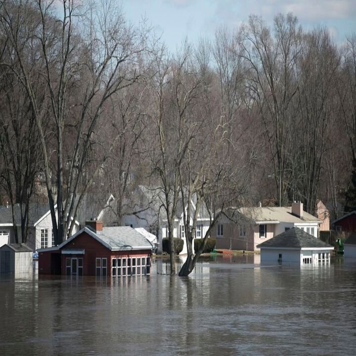 Houses partially submerged in extensive floodwaters, showing severe water damage in O Fallon, MO.