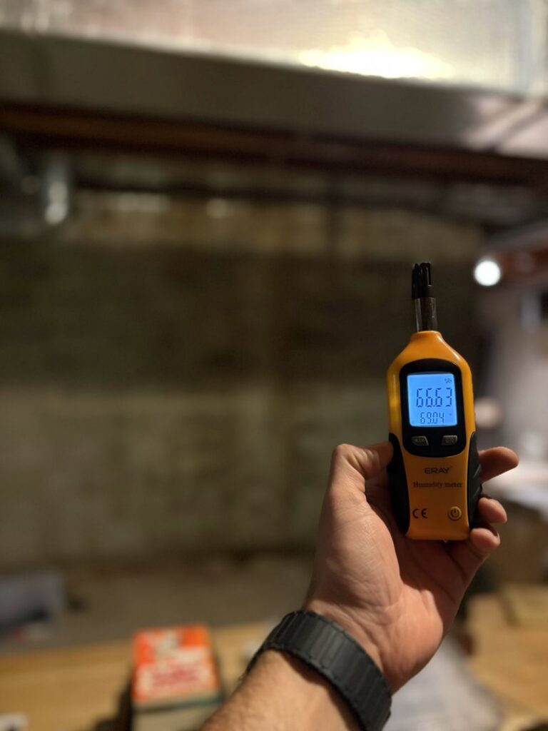 A professional holding a humidity meter to assess moisture levels during water damage assessment by Mold Master Restoration in Jersey City, NJ