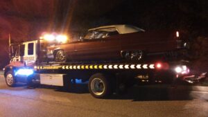 A Hummer H1 being loaded onto a flatbed tow truck by Baltimore Towing Service LLC in Owings Mills, MD.