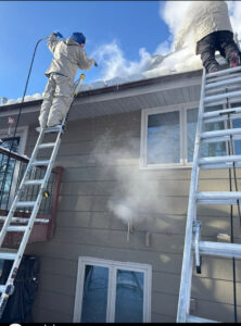 A water damage specialist from Keystone Home Services removing ice dams from a roof in Middletown, DE to prevent water damage.
