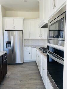 An immaculate kitchen with white cabinets and stainless steel appliances, showcasing the thorough cleaning by Sudz Up Cleaning Company in Columbia, MO.