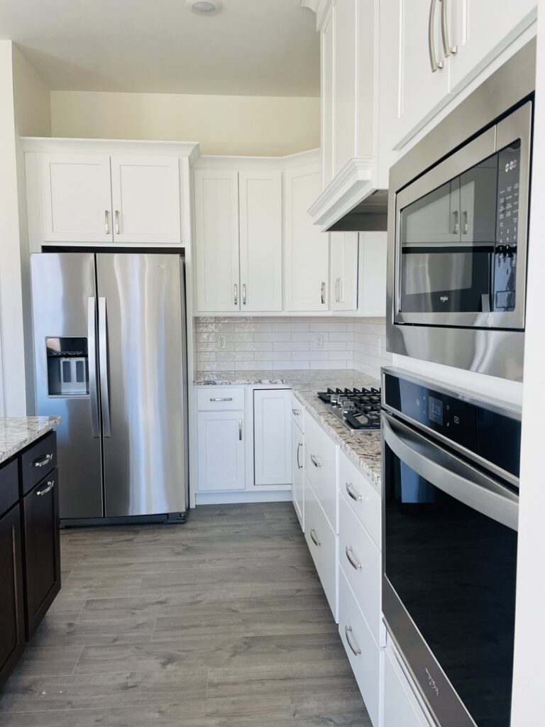 An immaculate kitchen with white cabinets and stainless steel appliances, showcasing the thorough cleaning by Sudz Up Cleaning Company in Columbia, MO.