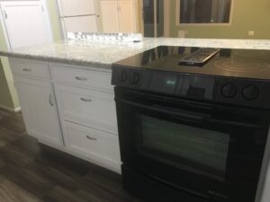 An immaculate kitchen featuring a clean stove and white cabinets, demonstrating A Clean Xscape LLC's house cleaning services in Chandler, AZ.