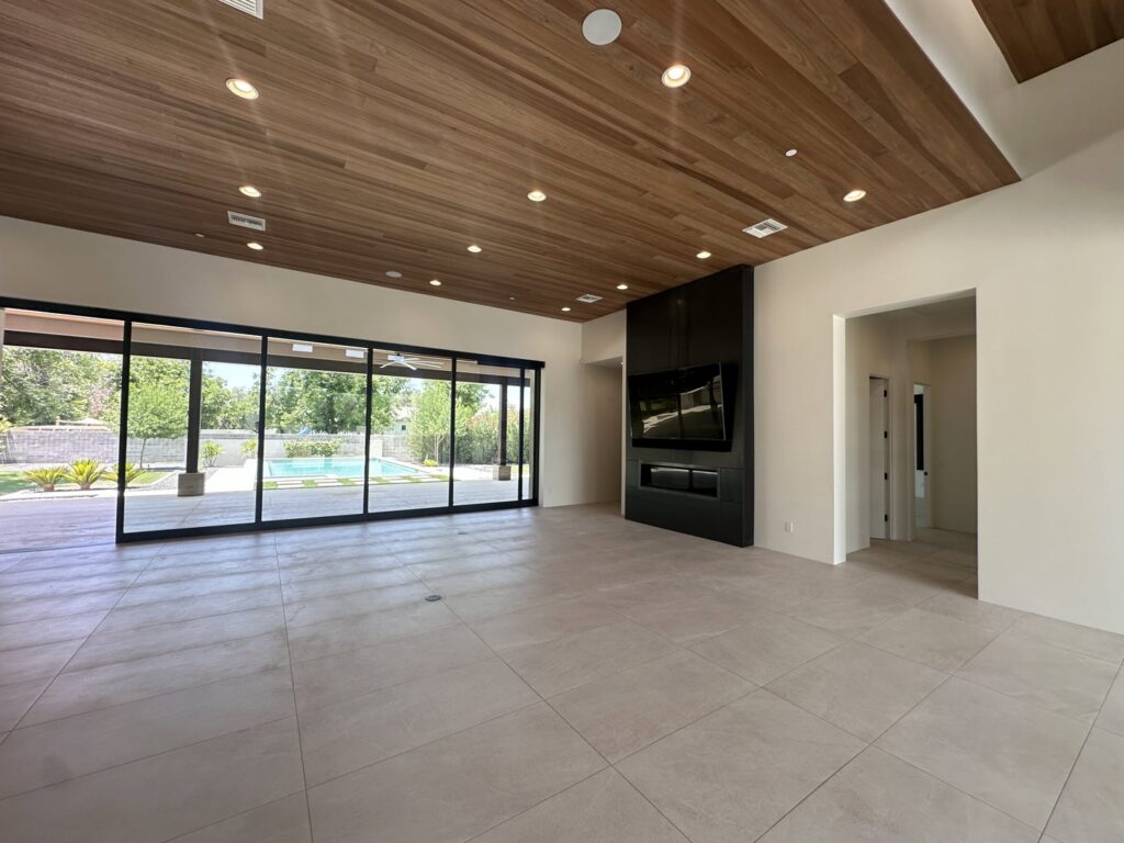 An immaculate living room with a view of a backyard pool, thoroughly cleaned by Cleaners of Arizona in Chandler, AZ.