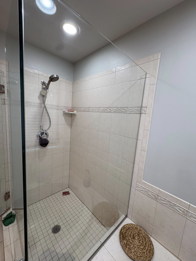 An immaculate tiled shower with clear glass enclosure, expertly cleaned by HDew Cleaning Co. in Madison Heights, MI.