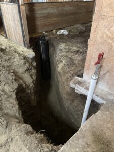 Indoor drainage pipe installation in a trench inside a barn by KD Services - Excavating in Bismarck, ND