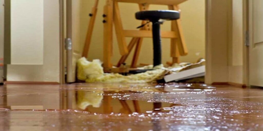 Pooled water on a wooden floor inside a building, showing clear indoor water damage addressed by Emergency Response Services Inc. in Warren, MI