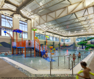 A vibrant indoor water park and pool facility with multiple slides and water features at Southern Prairie Activity & Recreation Center for Wellness in Wahpeton, ND.