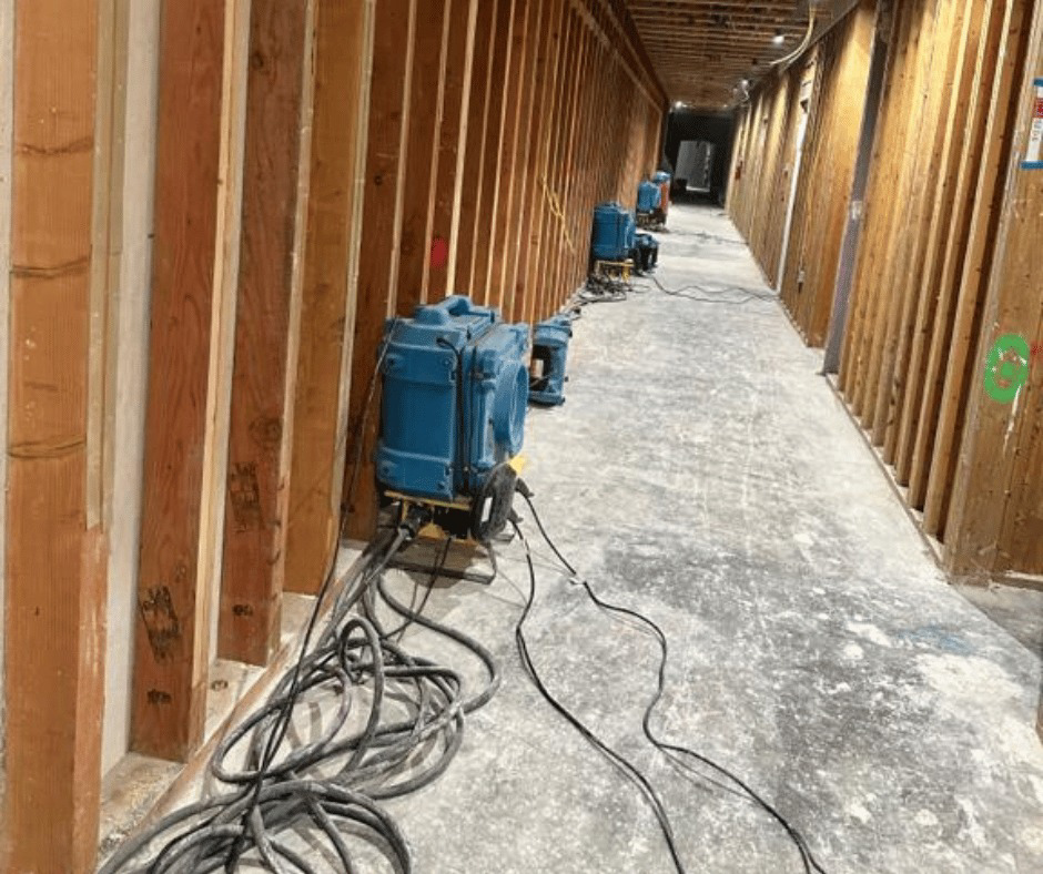 Industrial air movers and drying equipment set up in a hallway for water damage restoration by COIT Cleaning and Restoration in Indianapolis, IN