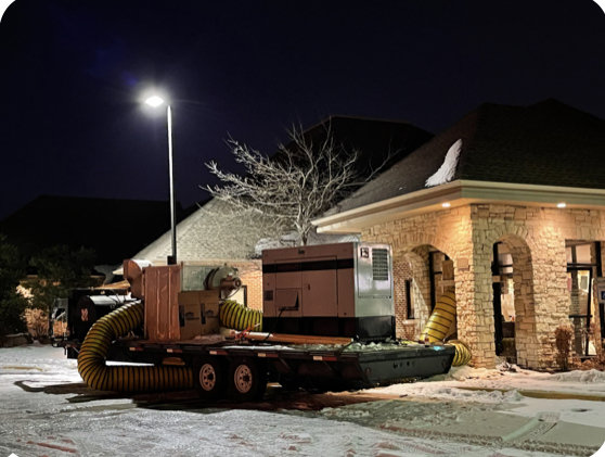 Large industrial drying equipment and hoses set up outside a commercial building at night for water damage restoration by Restoration 1 of OKC in Yukon, OK.