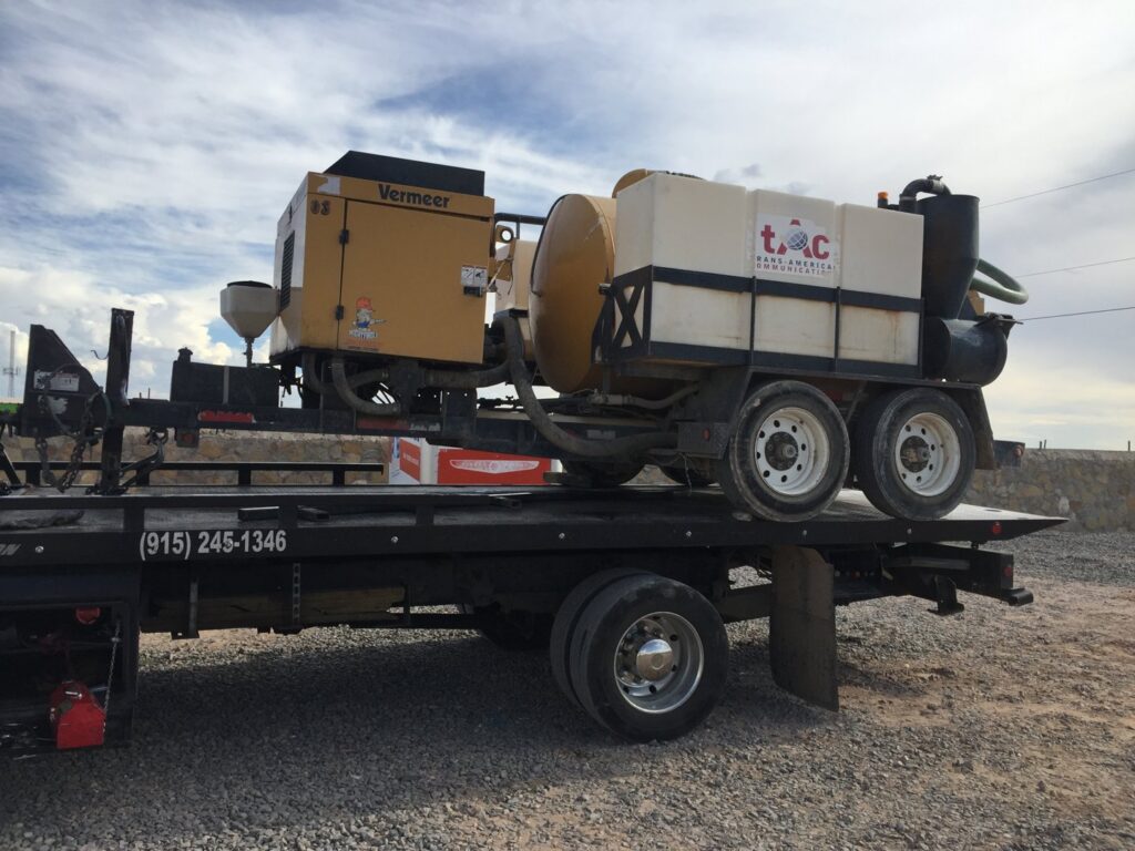 Industrial equipment being transported on a flatbed tow truck by Tow-Ro Towing in El Paso, TX.
