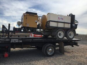 Industrial equipment being transported on a flatbed tow truck by Tow-Ro Towing in El Paso, TX.
