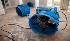 Industrial fans drying a water-damaged concrete floor during restoration by Emergency Response Services Inc. in Warren, MI