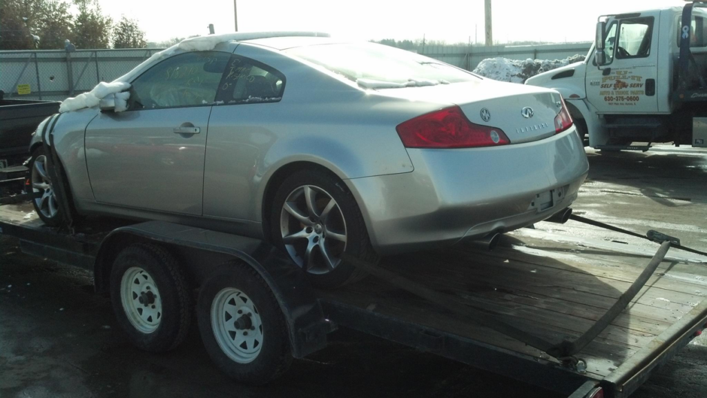 A silver Infiniti car on a flatbed trailer by Jr & Sr towing and recovery in Waukegan, IL.