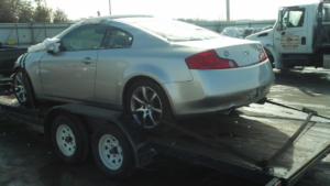 A silver Infiniti car on a flatbed trailer by Jr & Sr towing and recovery in Waukegan, IL.