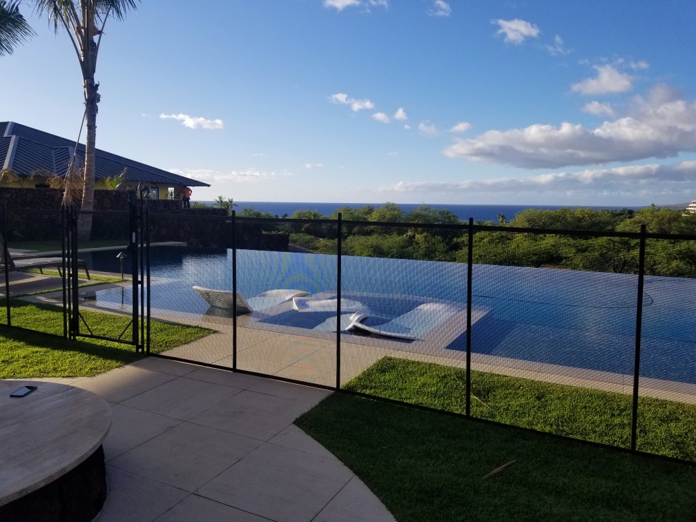 An infinity pool safety fence installed by Guardian Pool Fence Systems of Hawaii, offering protection with a stunning ocean view in Honolulu, HI.