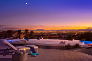A stunning infinity pool overlooking a city skyline at sunset, a luxury project by Purpose Pools in Henderson, NV.