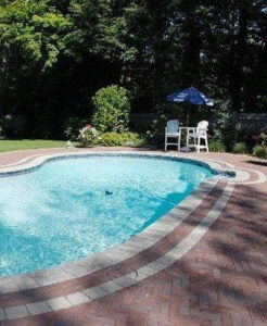 An inground pool surrounded by classic brick pavers, installed by Christman Pool Service in Portland, ME.