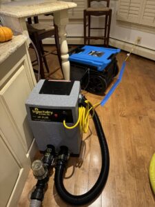 Injectidry HP-Plus machine with hoses in a kitchen for targeted water damage drying by Clean Care of New England in Cranston, RI
