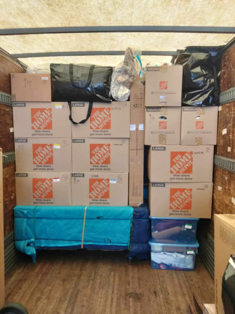 The interior of a moving truck expertly packed with moving boxes and furniture wrapped in blankets by E.L.I Movers LLC in Houston, TX.