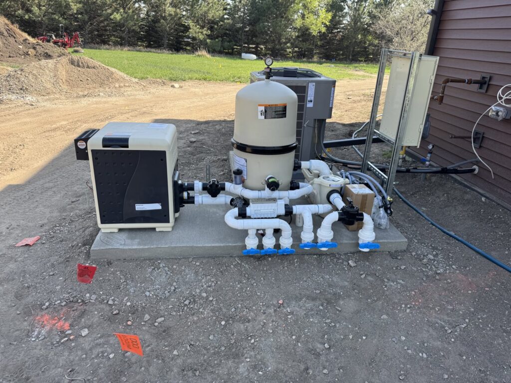 A fully installed pool equipment system with pumps, filters, and heater by Backyard Escapes by Kerner Pools & Spas in Bismarck, ND.