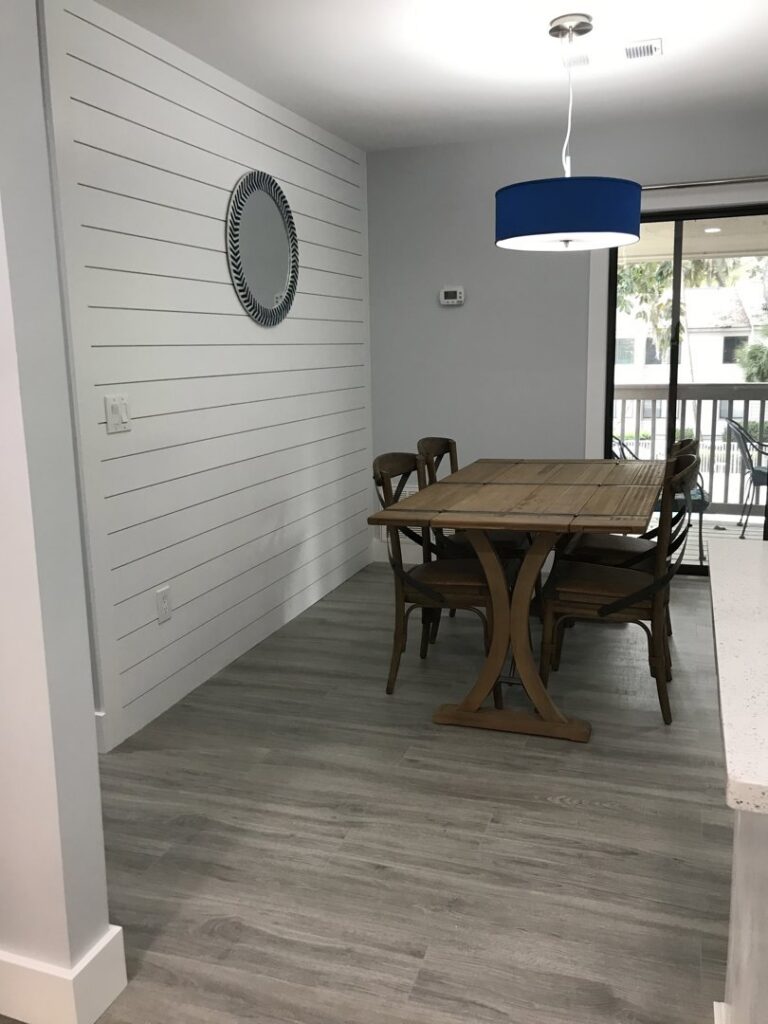 Two contractors inspecting exposed walls and wiring during an interior demolition project by HHI Builders in Hilton Head Island, SC.