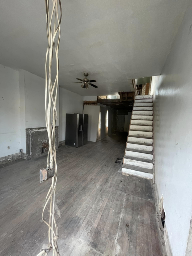Interior demolition showing a staircase, exposed wiring, and a partially removed fireplace by Identical Demolition LLC in Philadelphia, PA.