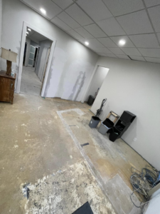 An interior room undergoing demolition with a stripped floor and exposed walls by Vaquero Demolition in Lewisville, TX.