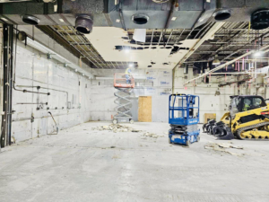 Interior demolition with worker on lift and skid steer by Orion Demolition & Environmental Services, LLC in Albany, NY.