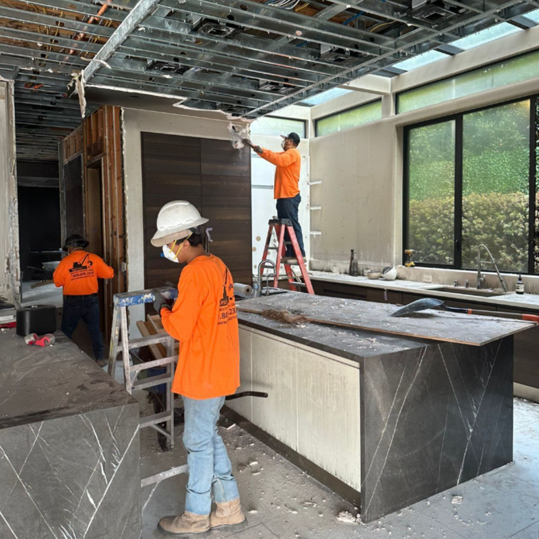 Workers performing interior demolition in a kitchen area for DEMO Leaders in Los Angeles, CA