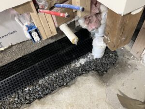 An interior drainage system with dimpled membrane and gravel installed by EFFECTIVE WATERPROOFING in Worcester, MA.