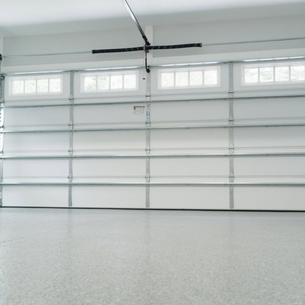 Interior view of a white sectional garage door showing tracks and opener mechanism by Oahu Garage Doors in Waipahu, HI