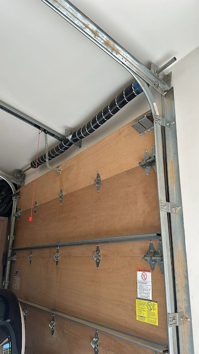 Interior view of garage door springs and tracks, indicating repair or maintenance by Ski Door, Inc. in Center Rutland, VT.