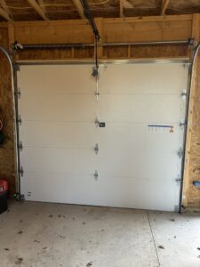 Interior view of a white garage door showing tracks and opener mechanism installed by Woodwards Overhead Door Co. in Topeka, KS