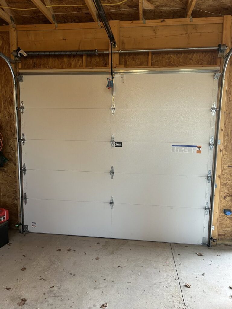 Interior view of a white garage door showing tracks and opener mechanism installed by Woodwards Overhead Door Co. in Topeka, KS