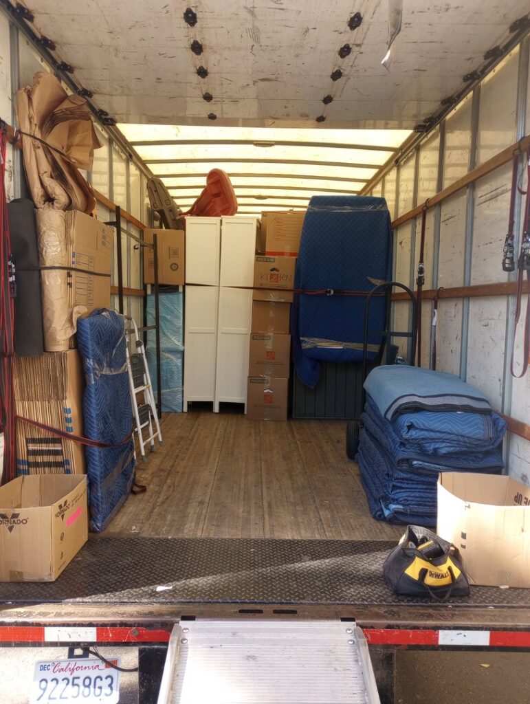 Interior view of a Packman Moving truck fully loaded with packed boxes and furniture in San Diego, CA