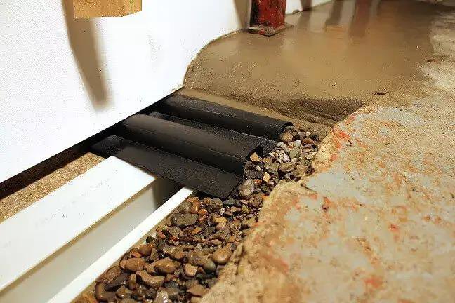 An interior perimeter drainage system installed along a basement wall for waterproofing by Basement Doctor of West Virginia, Parkersburg, WV.