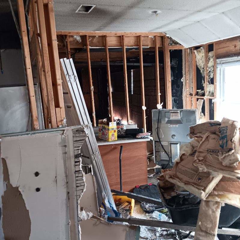 An interior room with exposed studs, insulation, and debris, indicating demolition work by HaysCo Facilities Management, Inc. in Dothan, AL.