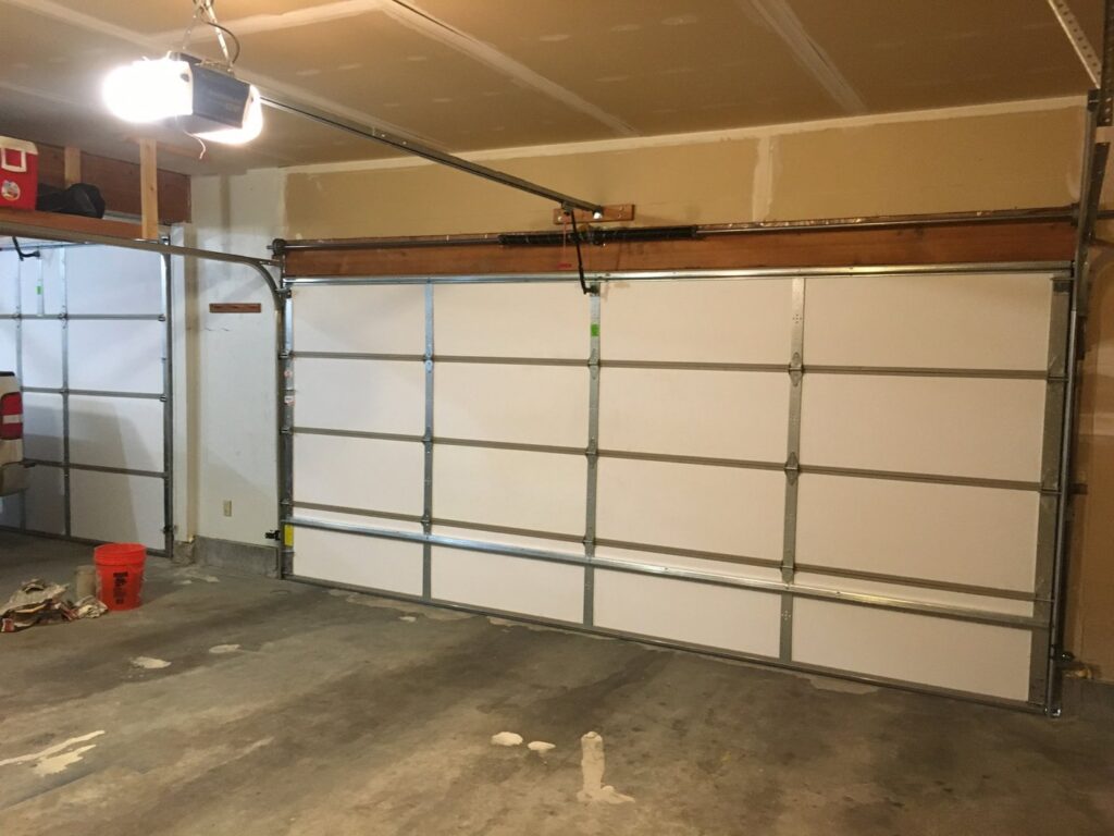 Interior view of two white panel garage doors with visible tracks and openers, installed by Elite Garage Door Service & Repair in Billings, MT.