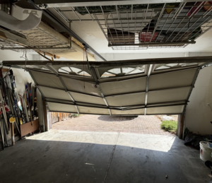 An interior view of a bent and damaged garage door, ready for repair by Summit-Overhead-Door in Sparks, NV.