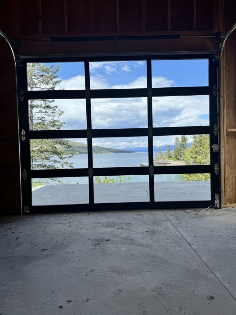 Interior view of a glass garage door looking out at a lake, installed by Riverside Garage Doors in Kalispell, MT.