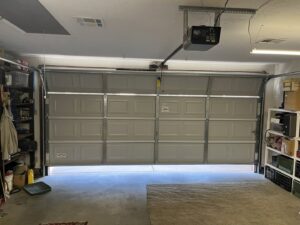 An interior view of a partially open garage door and its opener mechanism, showcasing work by Overhead Door Company of Albuquerque in Albuquerque, NM.