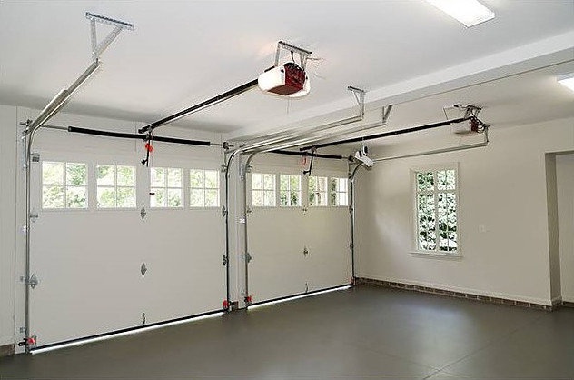 An interior view of a garage showing two installed garage doors and openers by Central Garage Door Service in Kapolei, HI.