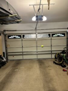 An interior view of a white garage door system with an opener and tracks, installed by Apex Garage Doors LLC in Las Vegas, NV