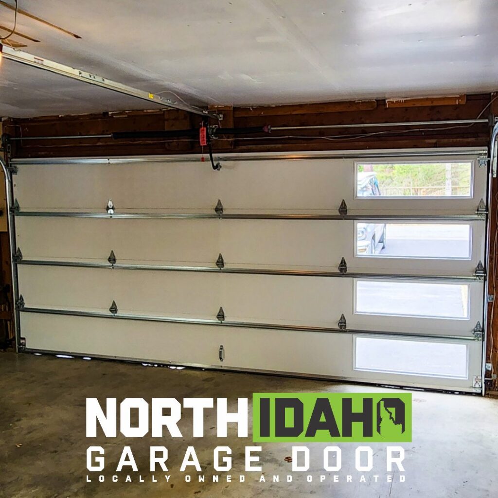 Interior view of a white garage door with visible tracks and opener, installed by North Idaho Garage Door in Coeur d'Alene, ID.