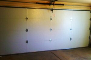 Interior view of a white garage door, showing the tracks and springs, installed by Mark's Garage Door Services in Santa Fe, NM.